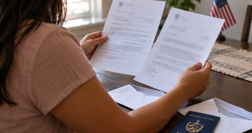 Dos cartas de inmigración renuevan la esperanza de una inmigrante cubana que lleva años esperando la residencia: “Esperemos que sea para algo bueno” Pasaporte cubano junto a los sobres